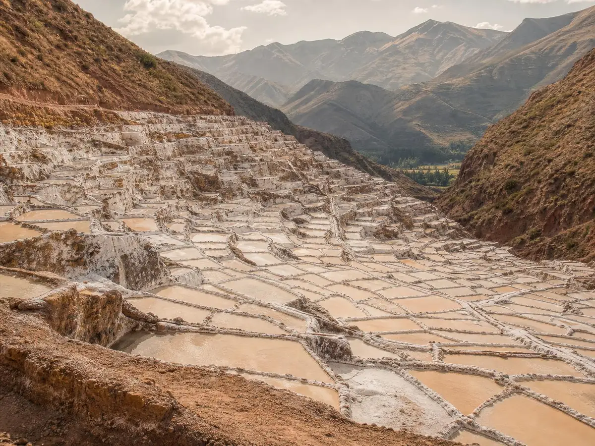 Las salinas de Maras en Cusco: cientos de pozas de evaporación escalonadas en la ladera, con las terrazas blancas y ocres descendiendo hacia el valle